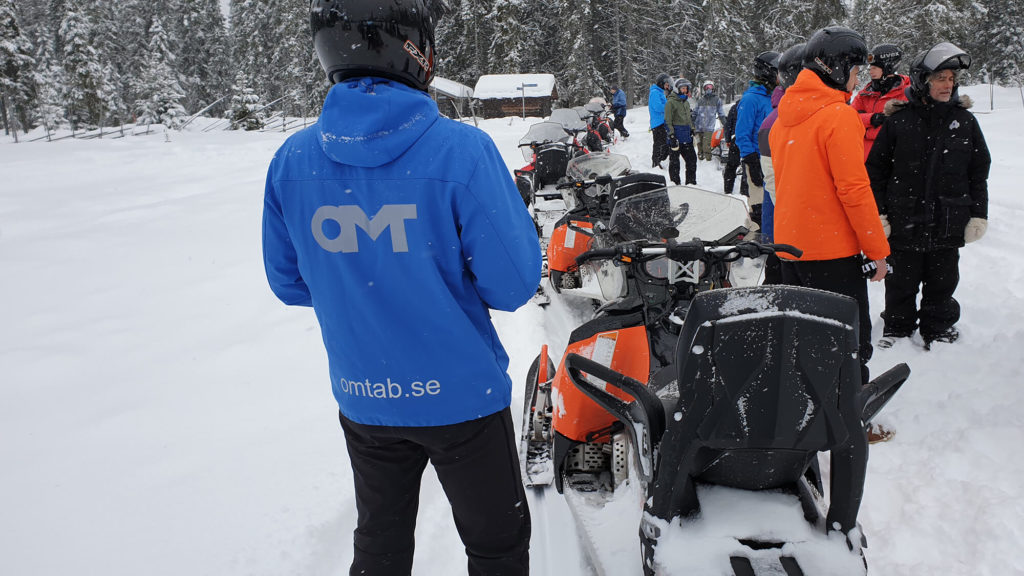 Persons in winter land with snowmobile